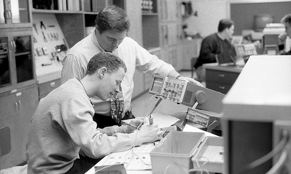 Engineering students working on a project under supervision of their instructor.
