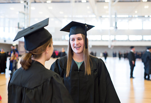 Graduates wait inside the gym area preparing to enter Commencement ceremony.