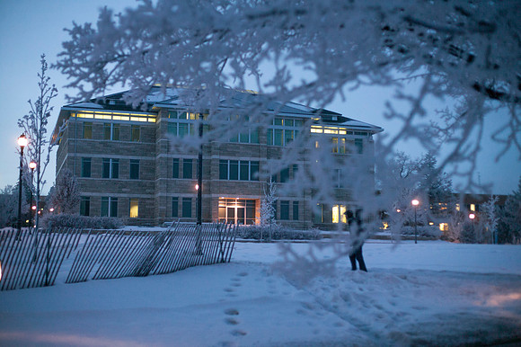 Fog sourrounds the Spori building as a student walks to their early morning class.