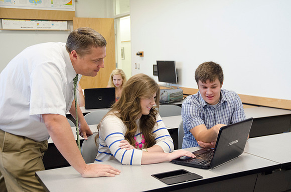Matt Miles helps students work on group project.