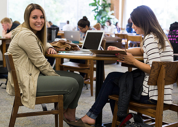 Students prepare for their classes, in the McKay Library.