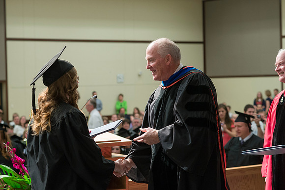 Elder Maynes and Pres Clark congratulate the graduates in the College of Language and Letters Convocation in the Manwaring Center Ballroom.