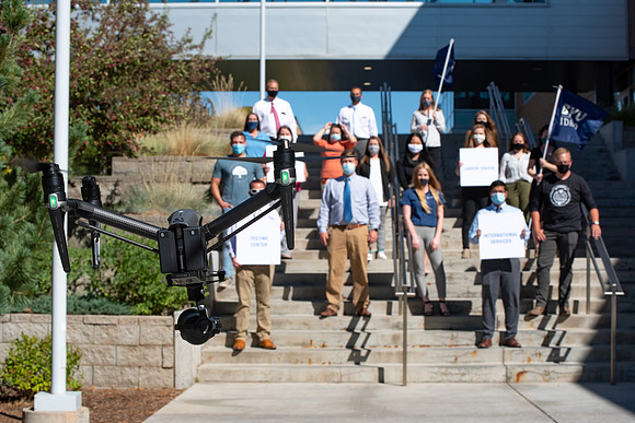 Drone shots of faculty groups around campus say "We're in this together."