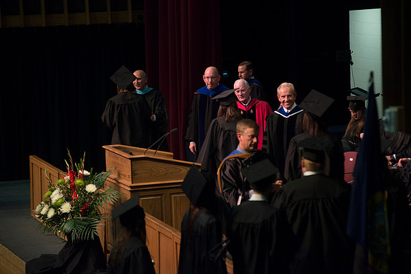 Elder W. Craig Zwick and President Kim B. Clark award diploma covers to graduates in the College of Business and Communication.