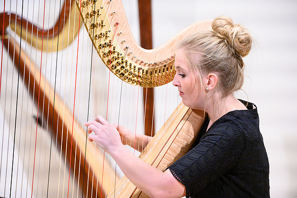 The harp ensemble performs in the recital hall in the Snow building.