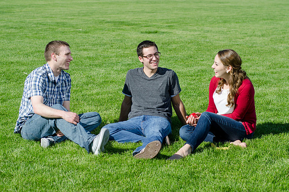Three friends laugh and enjoy talking on a sunny morning.