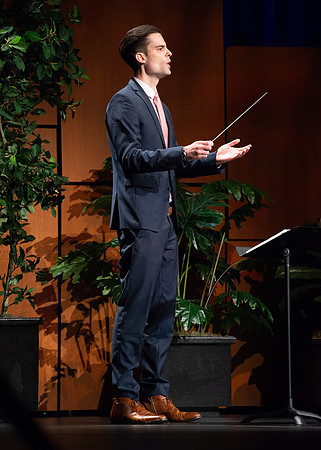 Director conducting the hymn to the audience.