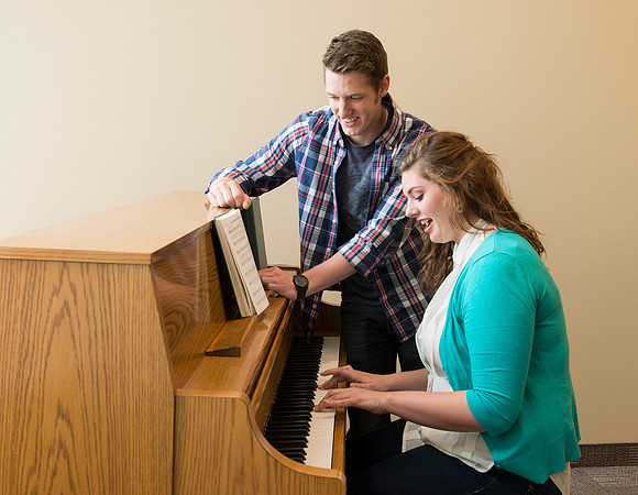 Students practice playing the piano for the new housing promo pictures.