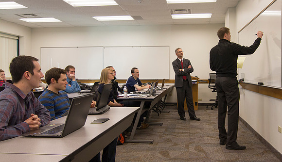 A student in Brother Packard's accouting class solves a problem on the whiteboard.