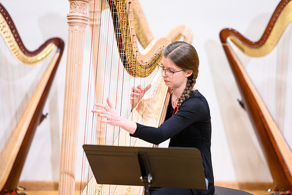 The harp ensemble performs in the recital hall in the Snow building.