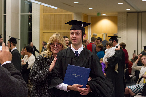 A graduate poses with his family after Convocation in the Taylor Chapel.
