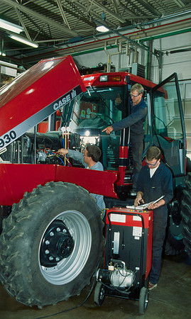 Students work on agriculture machinery in the shop