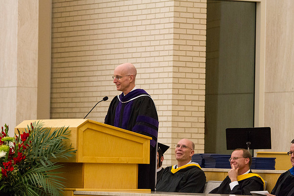 President Henry J. Erying talks to graduates and family in the Taylor Chapel during Convocation.