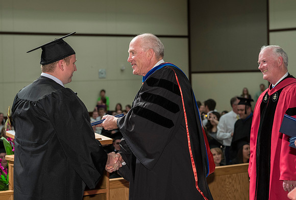 Elder Maynes and Pres Clark congratulate the graduates in the College of Language and Letters Convocation in the Manwaring Center Ballroom.