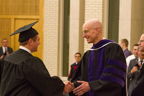 Advancement Vice President Henry J. Eyring congratulates a student in the Taylor Chapel.