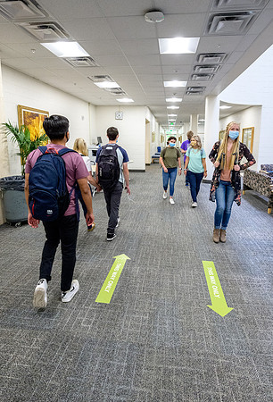 Student volunteers show the way to stay safe during this COVID 19 pandemic by social distancing, following pathway arrows and proper wearing of masks .
