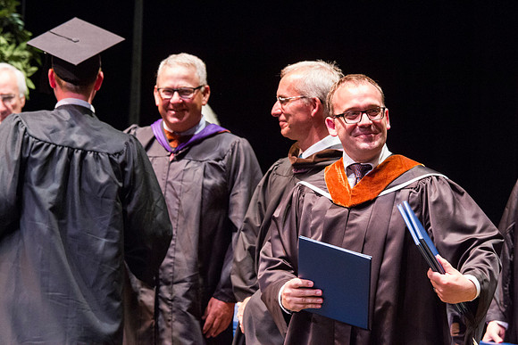 Dean's of the College of Performing and Visual Arts award diplomas to graduates during convocation held in the Snow Building. Photo by Tyler Rickenbach