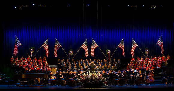 Members of the Collegiate Singers, Men's Choir, Women's Choir, and Symphony Band all perform together at the Patriots and Pioneers Concert.