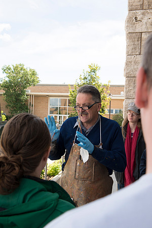 Brother Bodily talks to his students about the painting demonstration he is giving outside the Spori Building.